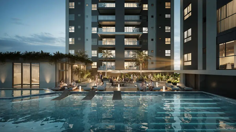 Piscina externa ao entardecer, com espreguiçadeiras e as torres ao fundo